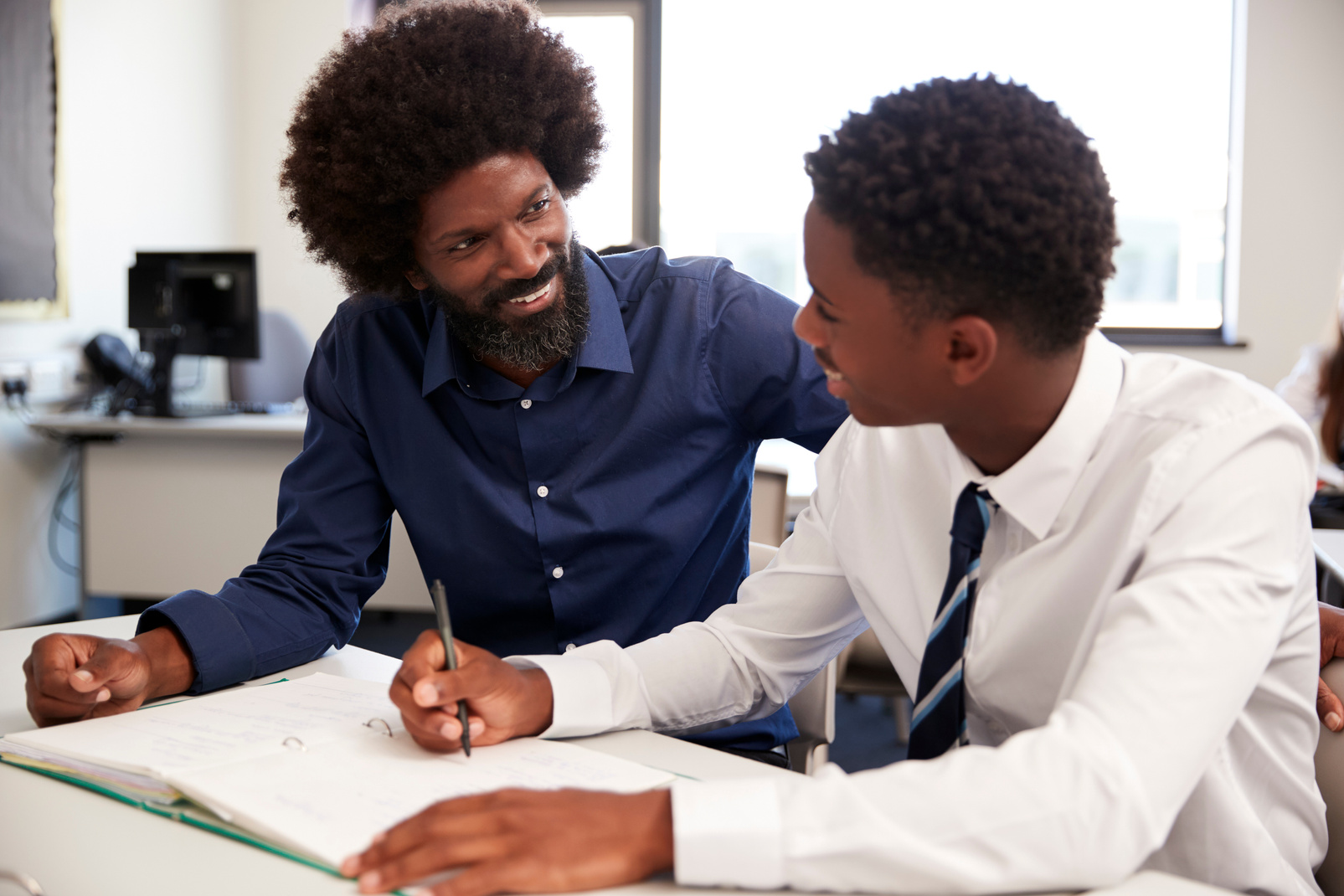 High School Tutor Giving Uniformed Male Student One to One Tuiti